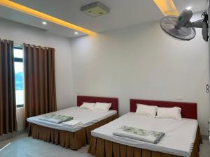 2 camas en una habitación con ventana en Nhà Nghỉ Cu Tí, en Bản Cong Na