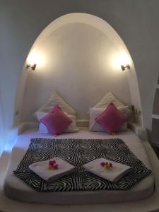 a bed with two pillows on top of it at Villa Hopedome in Teluk Nara
