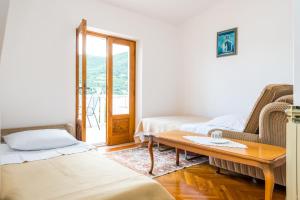 a living room with two beds and a coffee table at Villa Kukuljica in Zaton