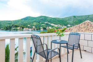 a table and chairs on a balcony with a view of the water at Villa Kukuljica in Zaton