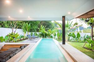 een zwembad in de achtertuin van een huis bij Modern Edgy Sophisticated Base, close to all - 2BR Villa in Canggu
