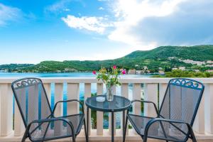 a table and chairs on a balcony with a view of the water at Villa Kukuljica in Zaton