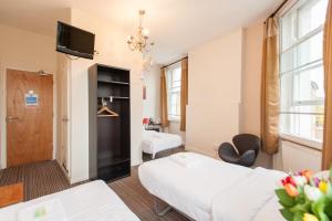 ein Hotelzimmer mit 2 Betten und einem TV in der Unterkunft New Market Ale House in London