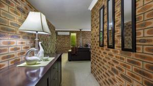 a room with a brick wall and a table with a lamp at Shady Trees Barrington in Barrington