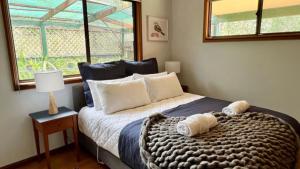 a bedroom with a bed with two towels on it at Carawa River Retreat in Coneac