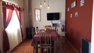 a dining room with a table and chairs and a television at La Comarca in Uspallata