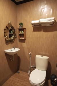 a bathroom with a toilet and a sink at d' Omah Afi 1 in Jarakan