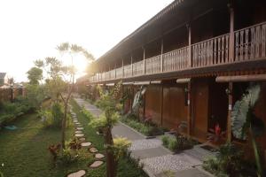 a building with a walkway next to a yard at d' Omah Afi 1 in Jarakan