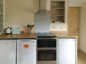uma cozinha com um fogão e um frigorífico em Cauldside West Cottage em Whitekirk