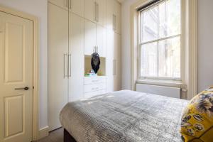 a bedroom with a bed and a window at NIRU Experience Huge Private Terrace In Chelsea in London