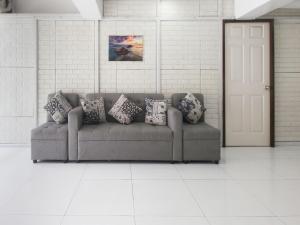 a couch in a white room with pillows on it at OYO 894 Cosmo Hotel P Campa Manila in Manila