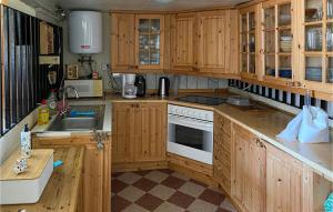een keuken met houten kasten en een witte kookplaat bij Beautiful Apartment In Morup With Wifi in Morup