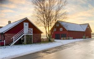 a red barn in the snow next to a road at Beautiful Apartment In Morup With Wifi in Morup