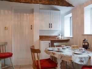 cocina con mesa, mesa y sillas en Richmond Cottage en Ashby Saint Ledgers