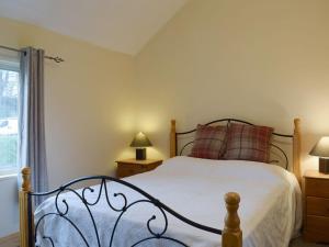 a bedroom with a bed and a window at Richmond Cottage in Ashby Saint Ledgers