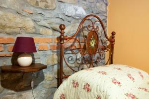 um quarto com uma cama e uma mesa com um candeeiro em La Collina dei Franchi em Camporgiano