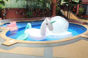 a pool with two inflatable toy animals in a swimming pool at Kudos Boutique Hotel in Nong Prue