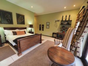 a bedroom with a bed and a table and chairs at 4 Bedroom Holiday Home, Bayhill, Whiteriver Country Estate in White River