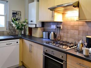 a kitchen with a stove and a counter top at 10 Elm Court in Keswick