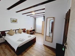 a bedroom with a bed and a mirror and a table at Confort INN in Otopeni