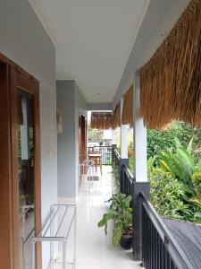 a hallway of a house with chairs and plants at Diary home stay in Ubud