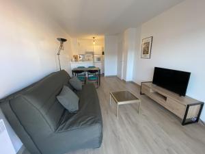 un salon avec un canapé et une télévision à écran plat dans l'établissement Appartement T2 en centre ville avec terrasse, wifi, Parking - FR-1-374-188, à Arcachon
