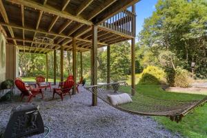 a patio with chairs and a hammock under a pavilion at Gorgeous Cottage with Hot Tub in Boone NC! in Boone