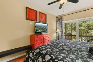 a bedroom with a bed and a television on a dresser at Gorgeous Cottage with Hot Tub in Boone NC! in Boone