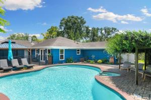 a swimming pool in front of a blue house at Stunning Pool and Chefs Kitchen NRG MedCenter in Houston