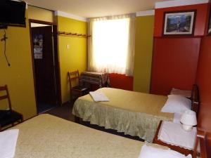 a hotel room with two beds and a window at El Álamo in Arequipa