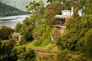 una casa al lado de una colina con un río en Hotel Antumalal, en Pucón