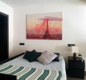 1 dormitorio con 1 cama con una foto de la torre Eiffel en DUPLEX 2 PLANTAS - c ALCALA-IFEMA-VENTAS- JARDIN & PARKING PRIVADOS- SUITES BOUTIQUE WH, en Madrid