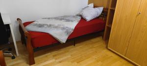 Cama pequeña en habitación con suelo de madera en Einzimmerwohnung mit Parkplatz ohne Küche en Bischweier