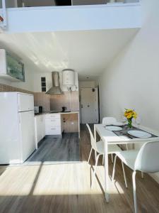 een witte keuken met een witte tafel en stoelen bij ESTUDIOS RUDA 4 in Madrid