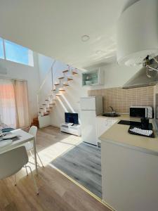 a kitchen with white appliances and a staircase at ESTUDIOS RUDA 4 in Madrid