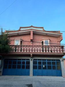 a large red brick building with a balcony on it at Olivos Habitación cuádruple in Tequisquiapan