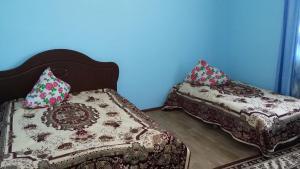 2 camas en una habitación con paredes azules en Apartments on Балауса, 2, en Aktau