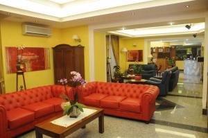ein Wohnzimmer mit zwei roten Sofas und einem Tisch in der Unterkunft Hotel Grillo Verde in Torre Annunziata