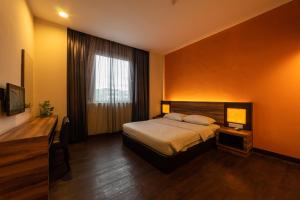 a hotel room with a bed and a window at Waterfront Boutique Hotel in Port Dickson