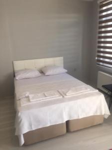 Cama blanca con sábanas y almohadas blancas en Zelya İstanbul flats, en Estambul