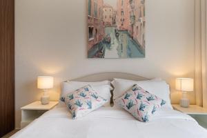 a bedroom with a white bed with two lamps at Alluring 1 BD Apartment in Business Bay with Burj Khalifa view in Dubai +7 photos