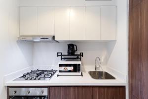 a white kitchen with a sink and a stove at Alluring 1 BD Apartment in Business Bay with Burj Khalifa view in Dubai