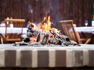 a fire is burning in a table with chairs at Kruger Eden Lodge in Marloth Park