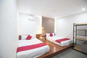 a bedroom with two beds with red and white sheets at Hoàng Bách Hotel in Vung Tau