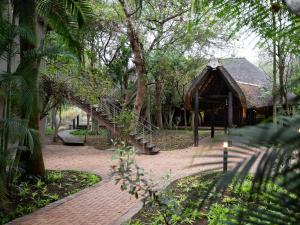 un pequeño edificio con una escalera en un parque en Kruger Eden Lodge en Marloth Park
