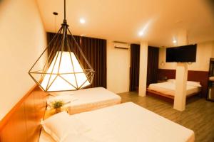 a hotel room with two beds and a chandelier at Hoàng Bách Hotel in Vung Tau