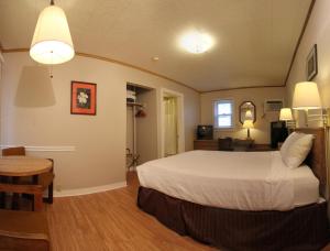 a bedroom with a bed and a desk and a table at Maple Leaf Motel in Littleton +26 photos