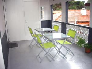 a patio with two tables and chairs on a balcony at Holidays Madeira in São Vicente