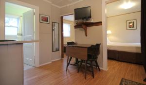 Habitación con escritorio y dormitorio con cama. en Maple Leaf Motel, en Littleton