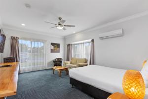 una camera d'albergo con letto e scrivania di The International Motel a Apollo Bay